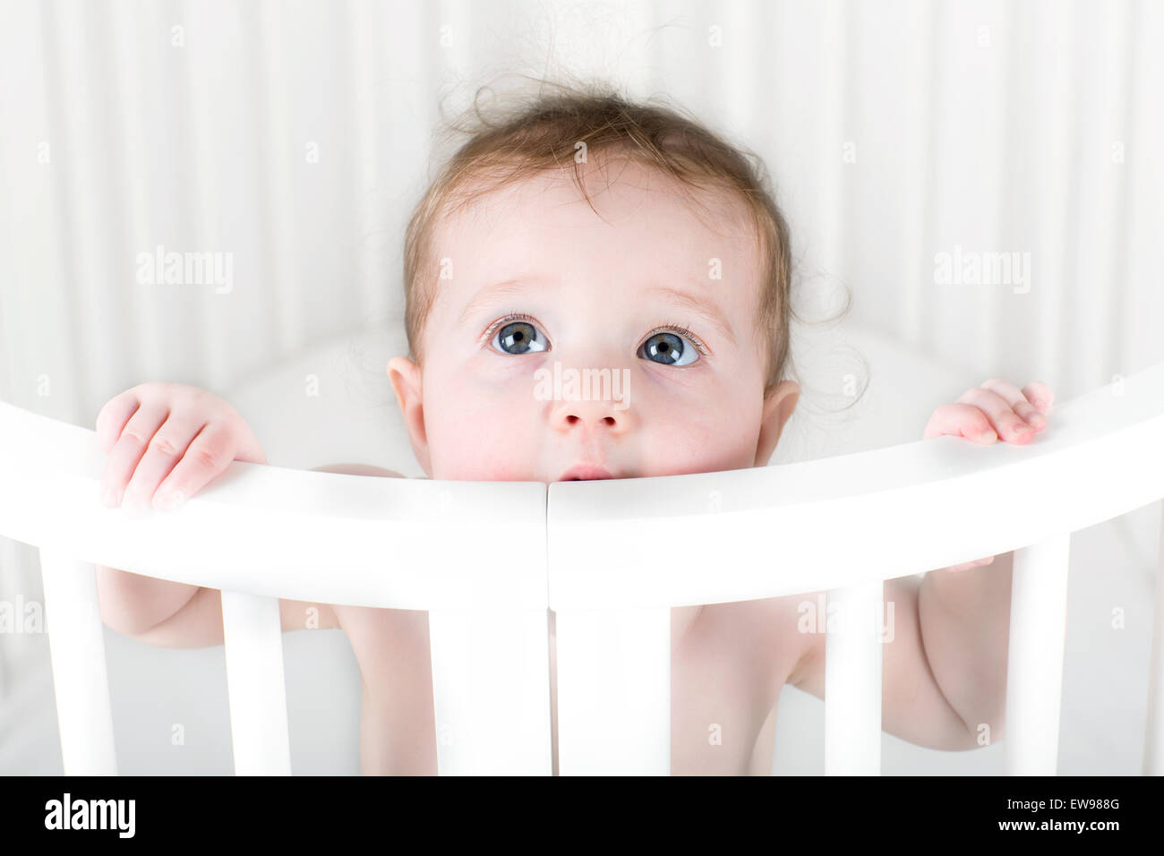 Funny teething baby biting on its crib Stock Photo Alamy