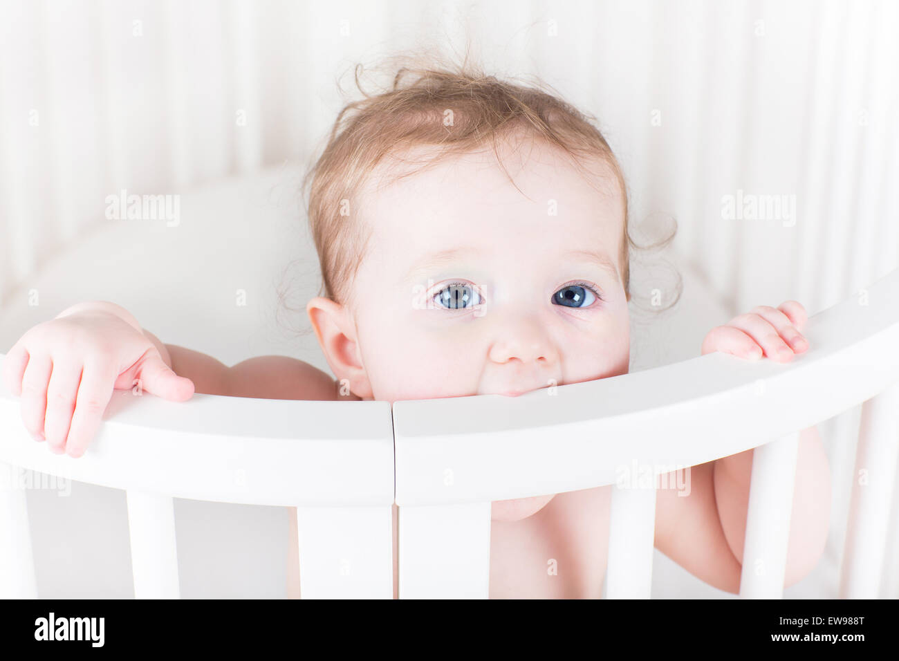 Happy funny baby biting on its crib Stock Photo Alamy