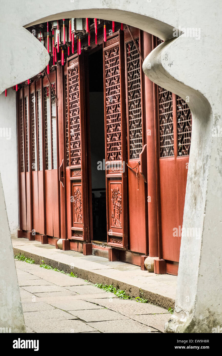 Ornate traditional Chinese style wooden doors viewed through an archway