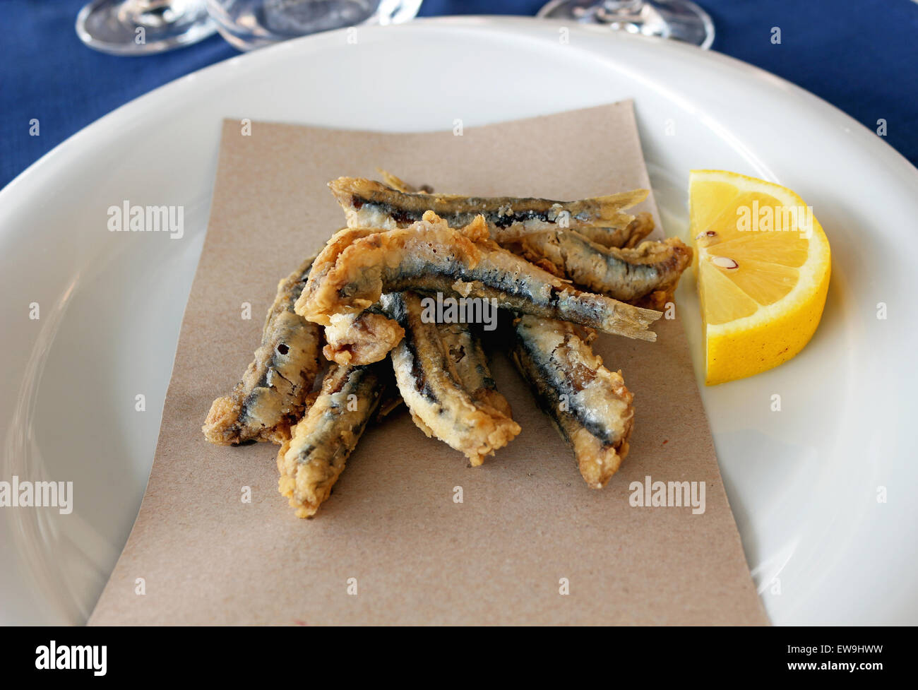 Fried anchovies with lemon on a plate Stock Photo