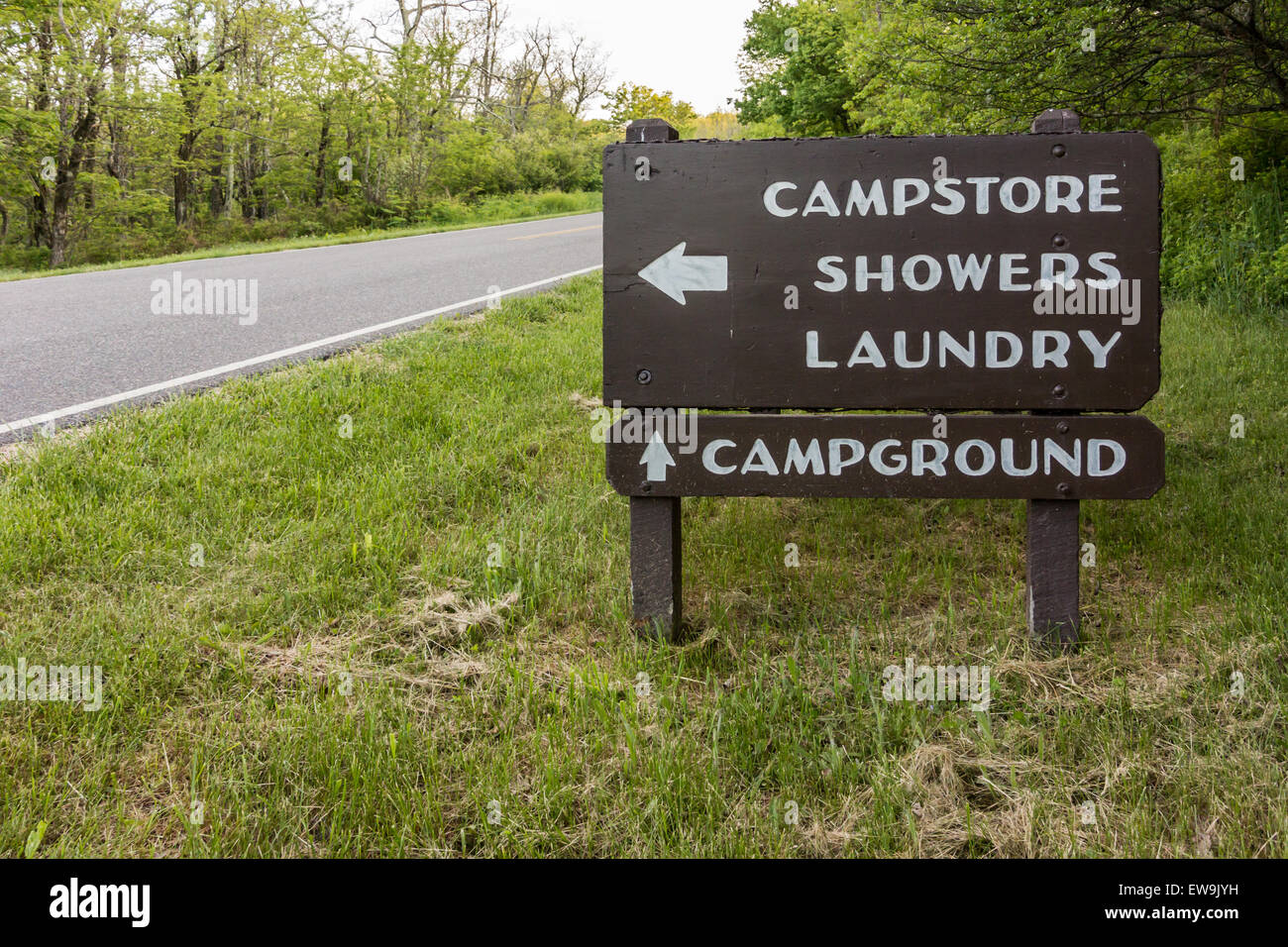 A sign points camp visitors to the store, laundry and shower facilities, and camp sites Stock Photo