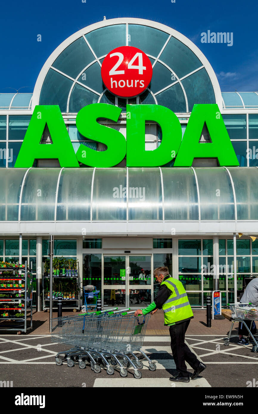Man Pushing Trolleys, Asda Supermarket Exterior, Brighton, Sussex, UK Stock Photo