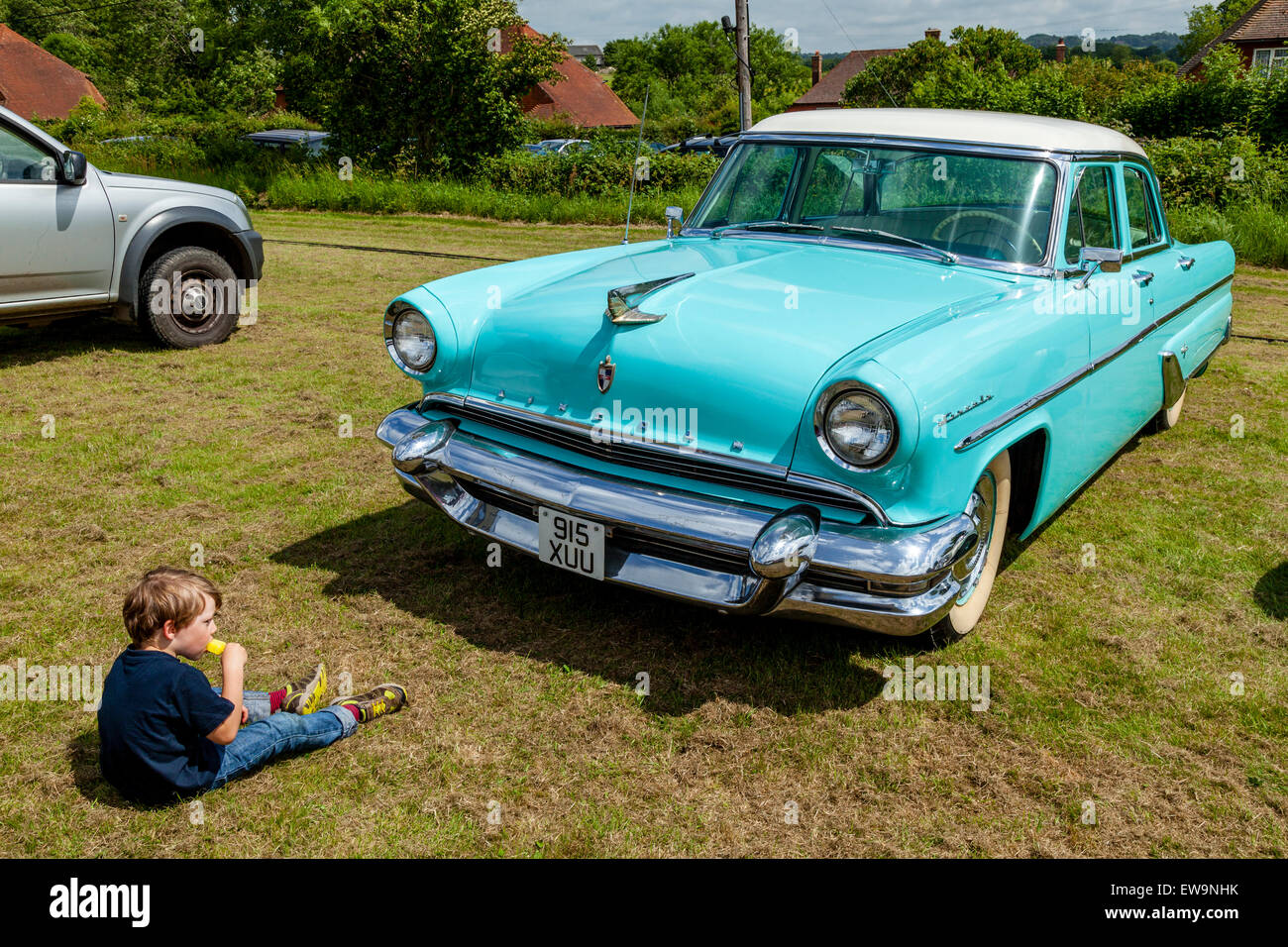 Young Boy Eating Ice Lolly By A Classic Lincoln Car, High Hurstwood Fete, High Hurstwood, Sussex, UK Stock Photo