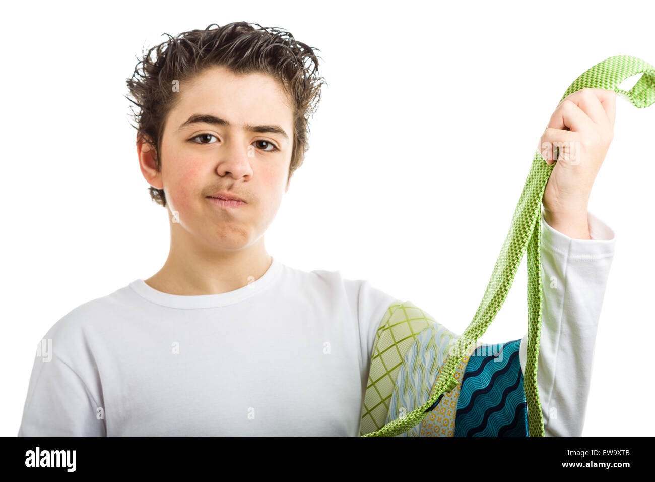 Puzzled hispanic boy in white long sleeved shirt smiles holding some extravagant and tawdry green ties Stock Photo