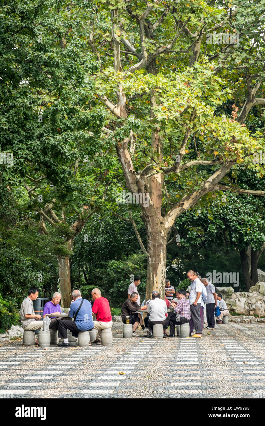 People sitting around tables under tree Stock Photo