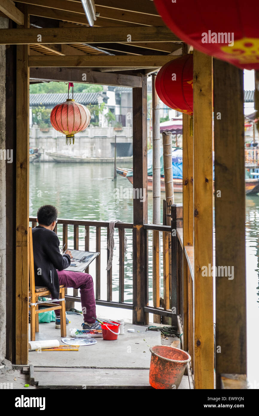 Artist painting gondolas on the canal in the historic scenic Zhouzhuang water town, China Stock Photo