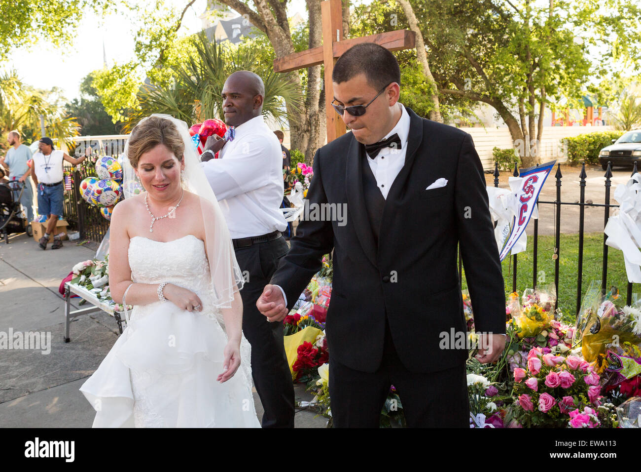 Newlyweds stop to pay respect at a makeshift memorial outside the historic mother Emanuel African Methodist Episcopal Church in their wedding cloths June 20, 2015 in Charleston, South Carolina. Earlier in the week a white supremacist gunman killed 9 members at the historically black church. Stock Photo