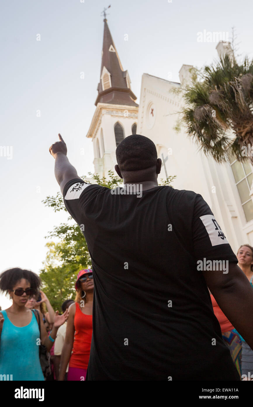 Mourners pray and sing spirituals at a makeshift memorial outside the historic mother Emanuel African Methodist Episcopal Church June 20, 2015 in Charleston, South Carolina. Earlier in the week a white supremacist gunman killed 9 members at the historically black church. Stock Photo
