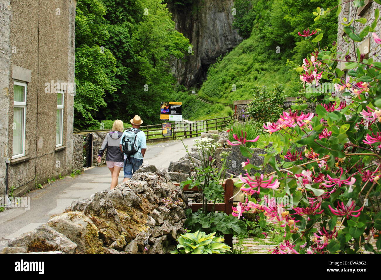 A man and woman approach the entrance to Peak Cavern at Castleton, Peak District National Park ,Derbyshire, UK Stock Photo