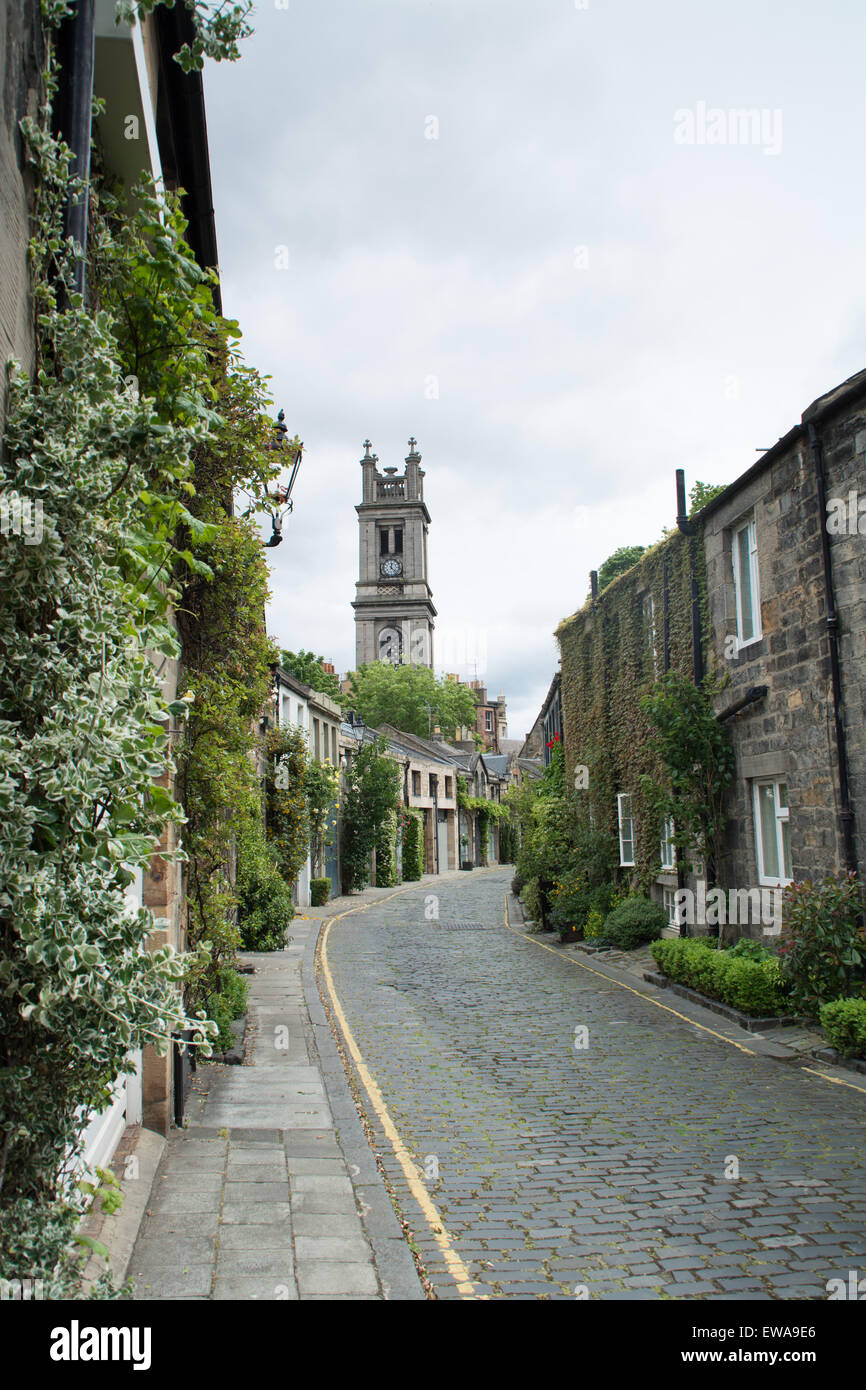Beautiful cobbled street Circus Lane with Saint Stephen's Church tower in the background. Edinburgh, Scotland Stock Photo