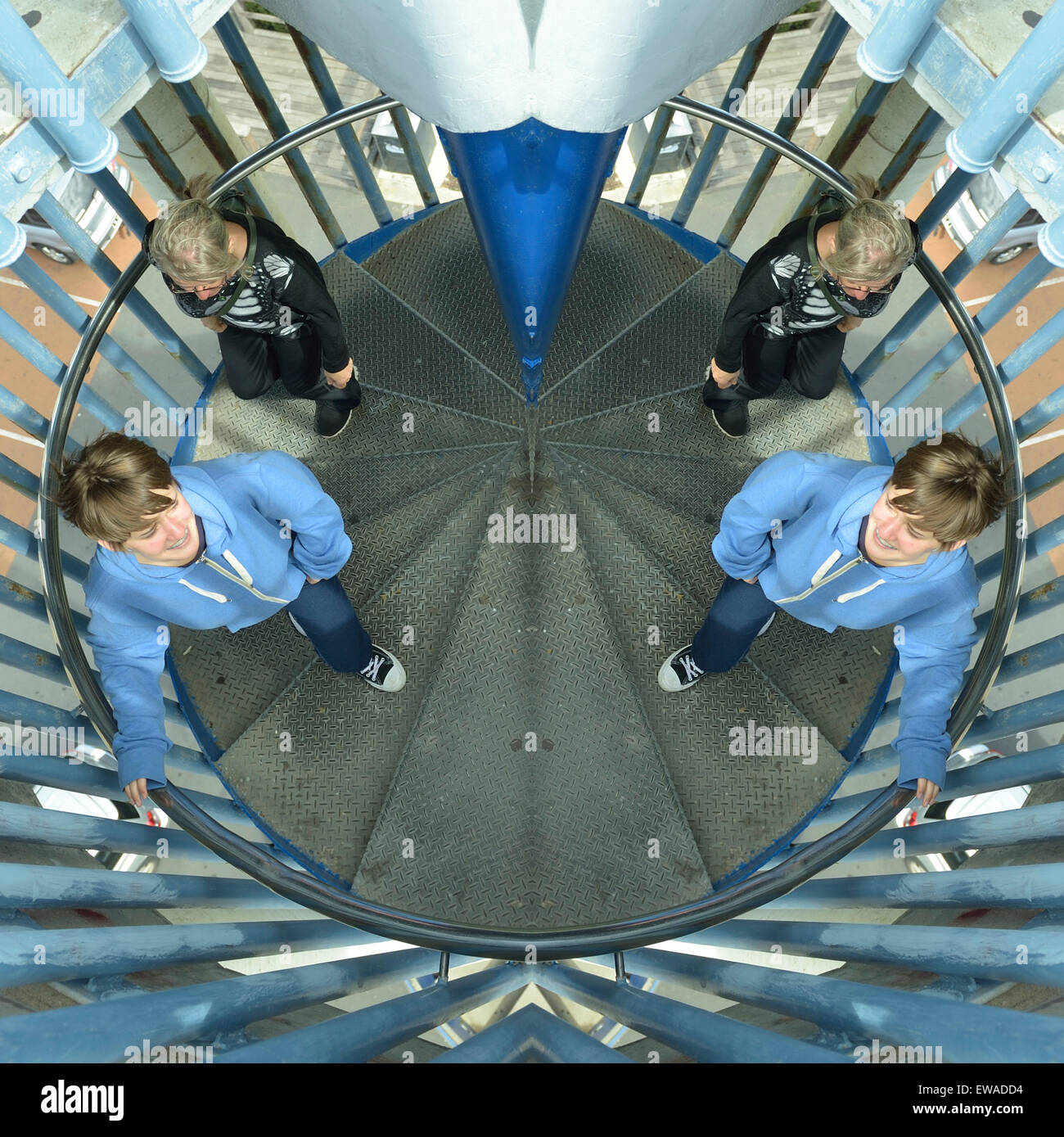 Vertically split, mirrored and horizontally flipped image of two young women on spiral staircase Stock Photo