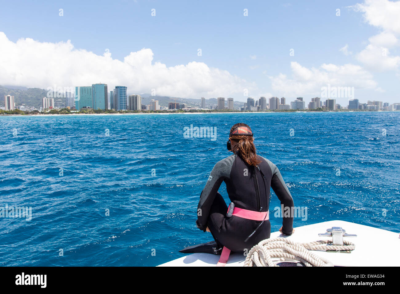 A female diver prepares to jump off the dive boat near Waikiki Beach in