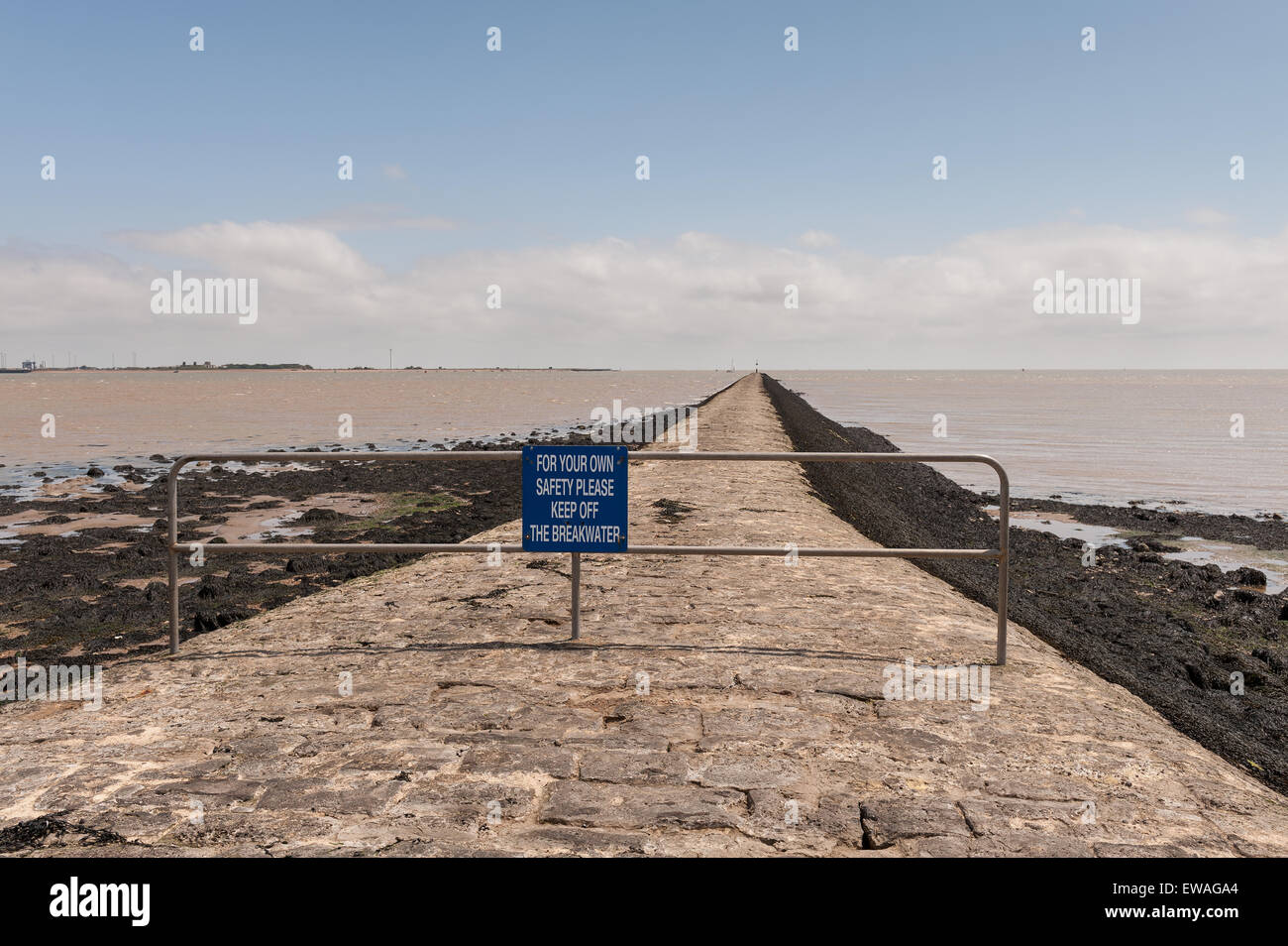 Long breakwater at Harwich with seaweed coated steep slopes dangerous risk of accidentally slipping falling into strong currents Stock Photo