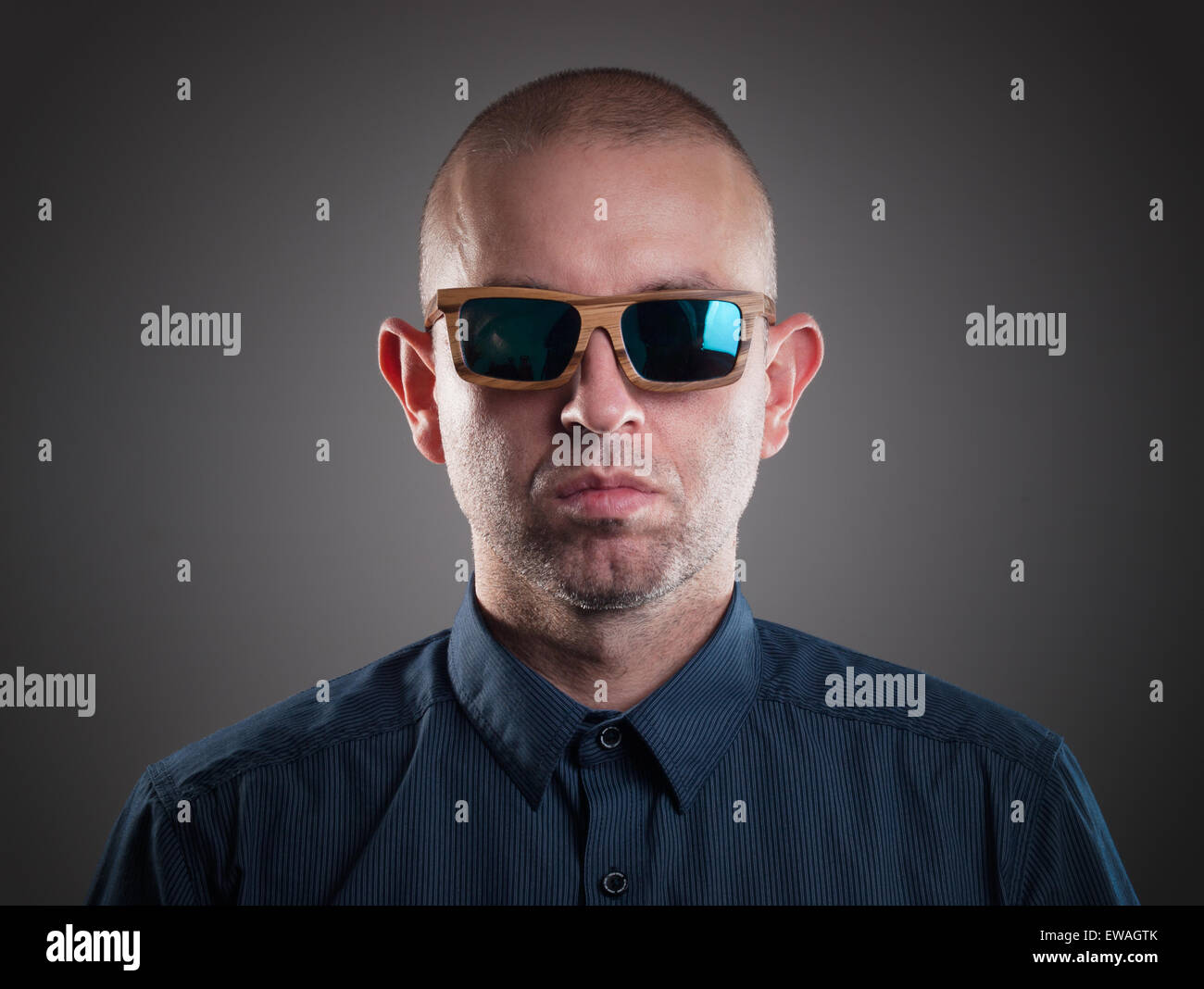 Man with sunglasses in a studio shot and looking at camera Stock Photo ...