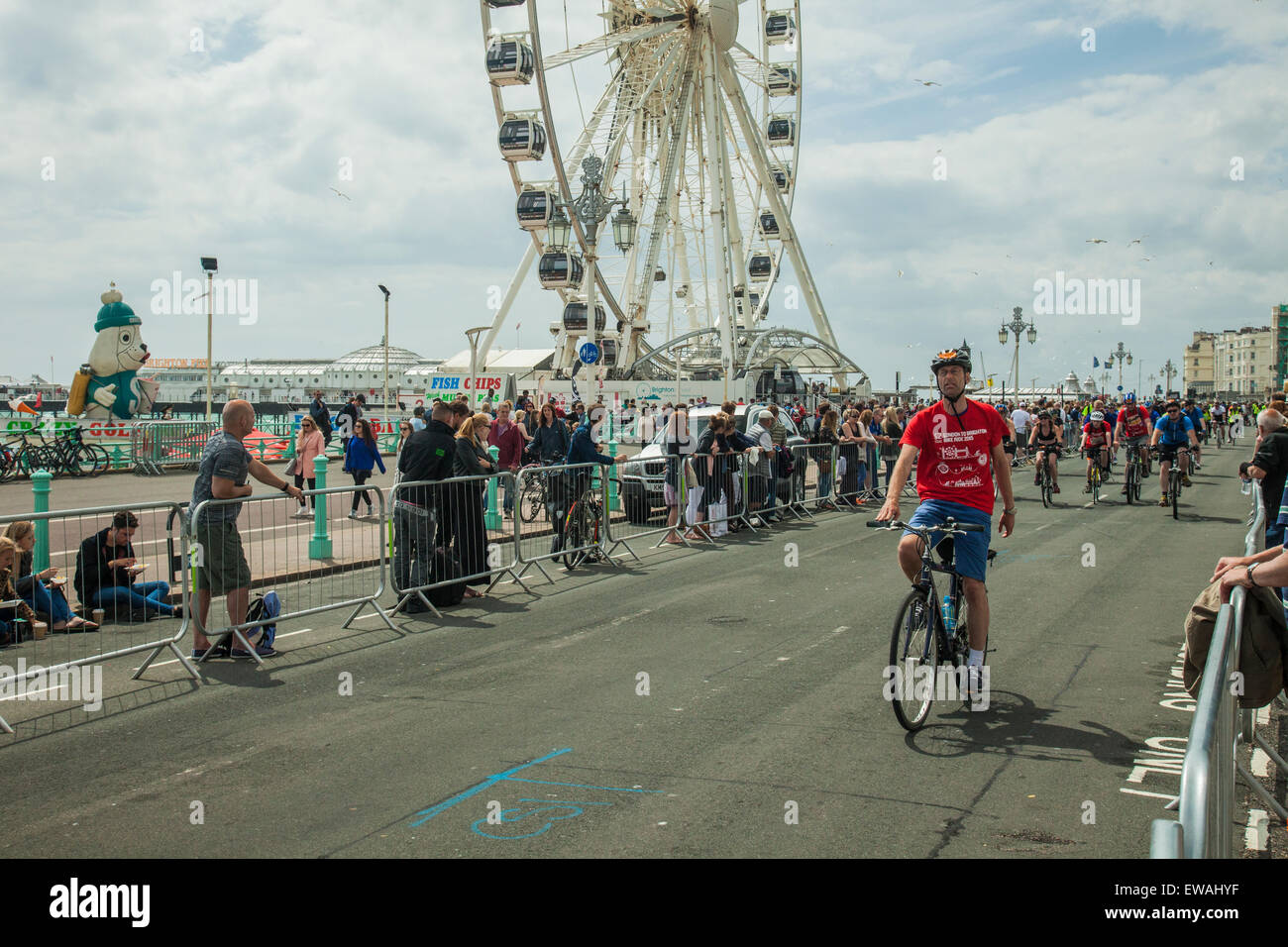 Brighton, UK. 21st June, 2015. Cyclists head for the finish line on Brighton seafront.  Onlookers stand at the barriers. Brighton Wheel in the distance. Credit:  Slawek Staszczuk/Alamy Live News Stock Photo