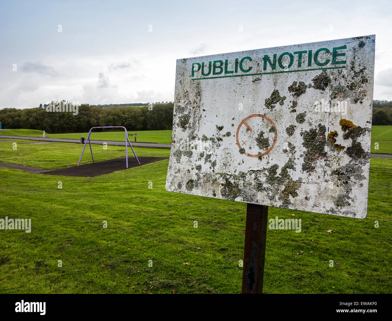 A cryptic notice in a Welsh public park, so old that it has become encrusted with lichen and all the information has faded away Stock Photo