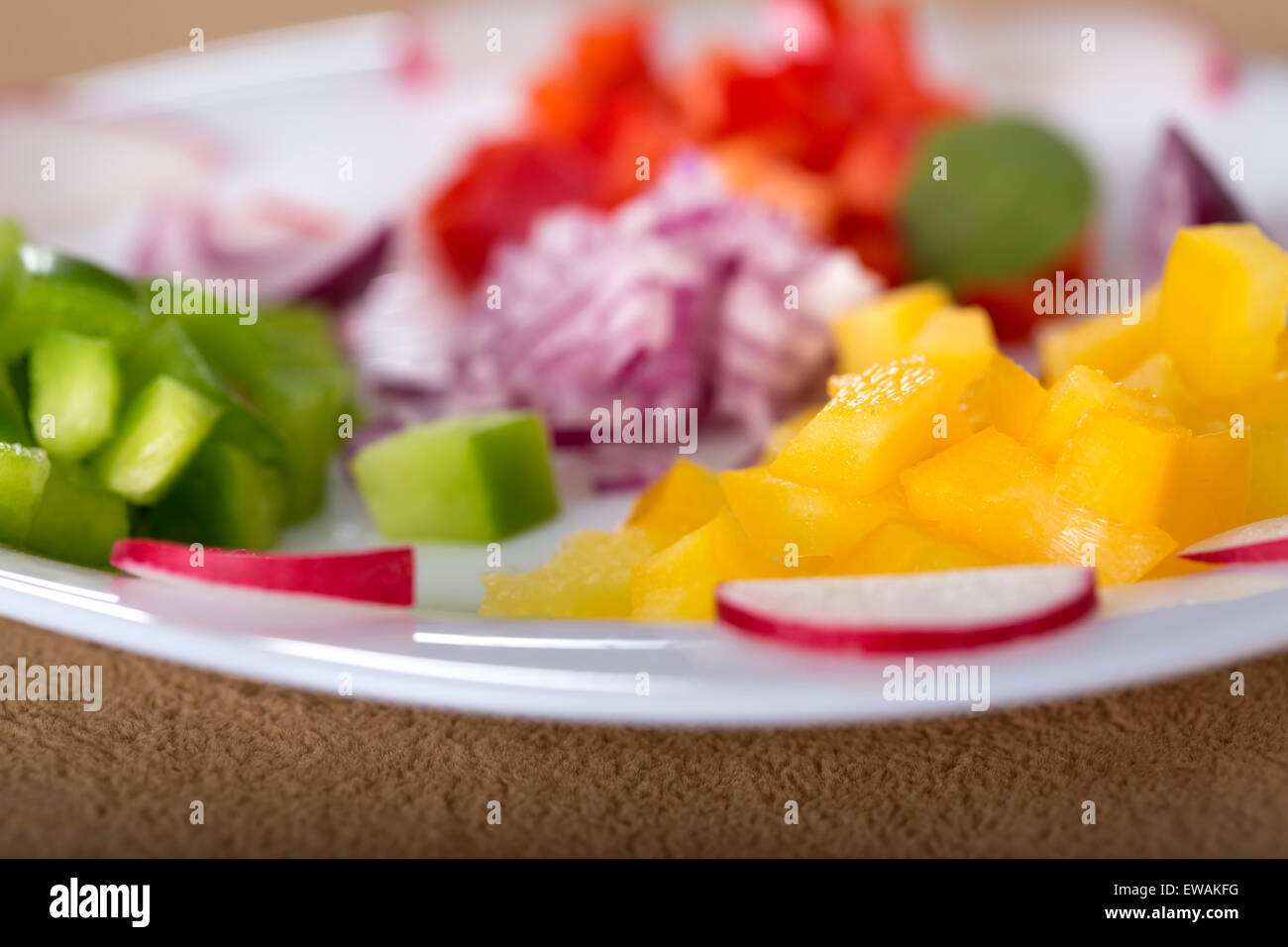 Close up of some fresh chopped vegetables on white plate for salad Stock Photo
