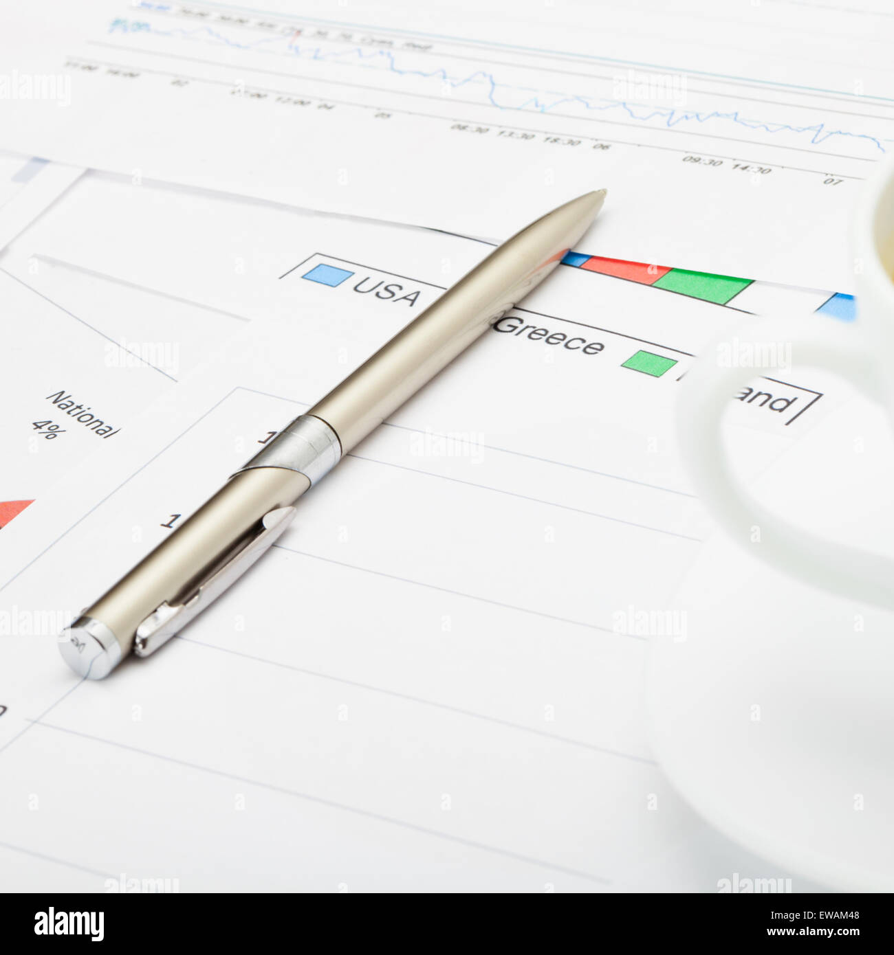 Pen and coffee cup financial charts close up Stock Photo Alamy