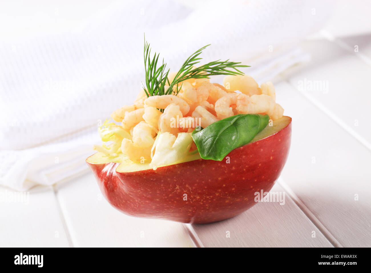 Half apple topped with shrimps Stock Photo