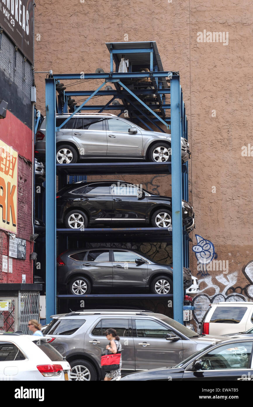 Cars parked vertically, Parking lift, multilevel sysytem, elevator against building. New York, Manhattan, USA. Stock Photo