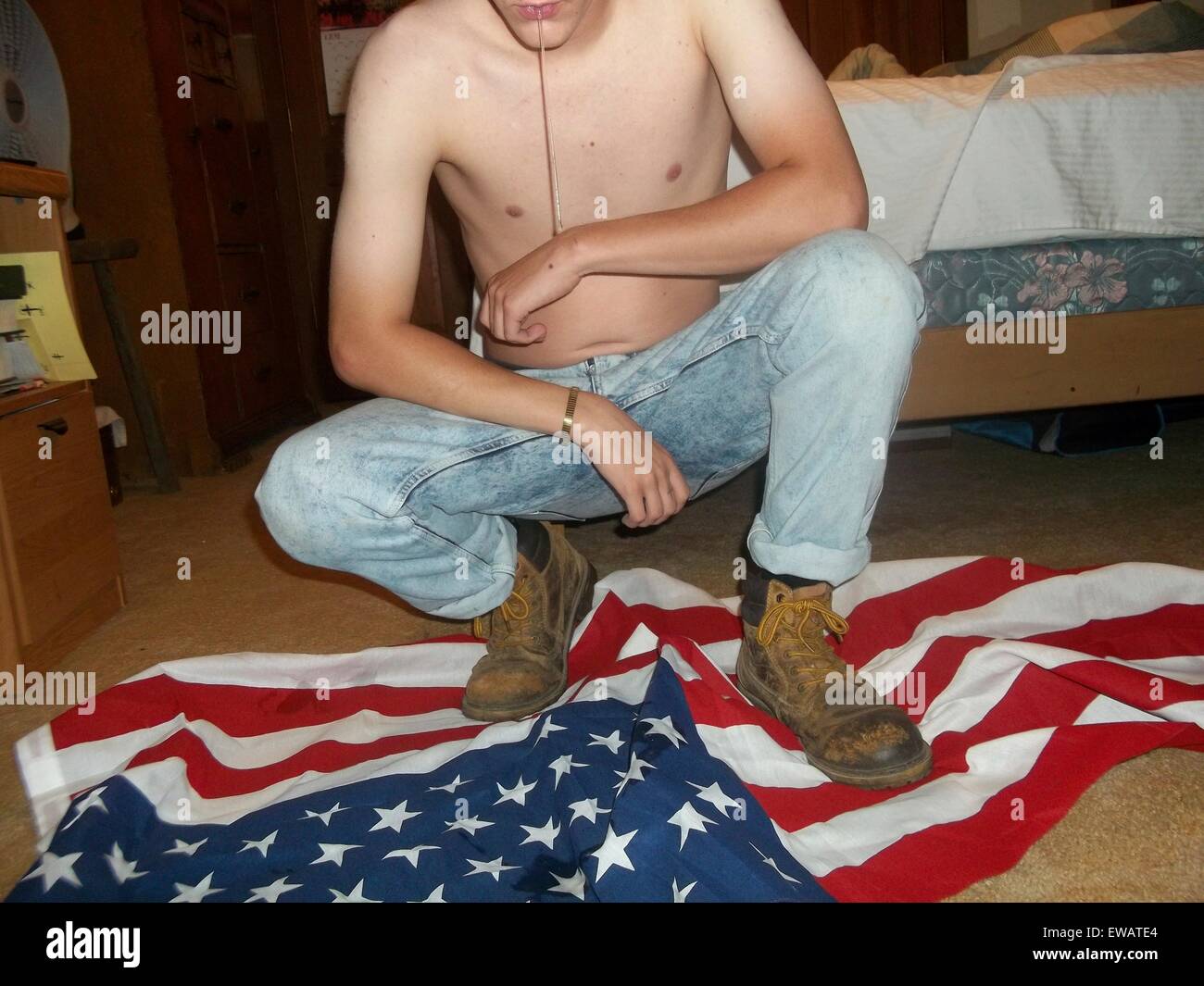 Charleston, South Carolina, USA. 21st June, 2015. A photo from a white supremacist website showing Dylann Storm Roof stepping and spitting on an American flag March 11, 2015. Roof murdered nine members of the Emanuel African Methodist Episcopal Church in a racially motivated killing on June 17, 2015 in Charleston, S.C. Credit:  Planetpix/Alamy Live News Stock Photo