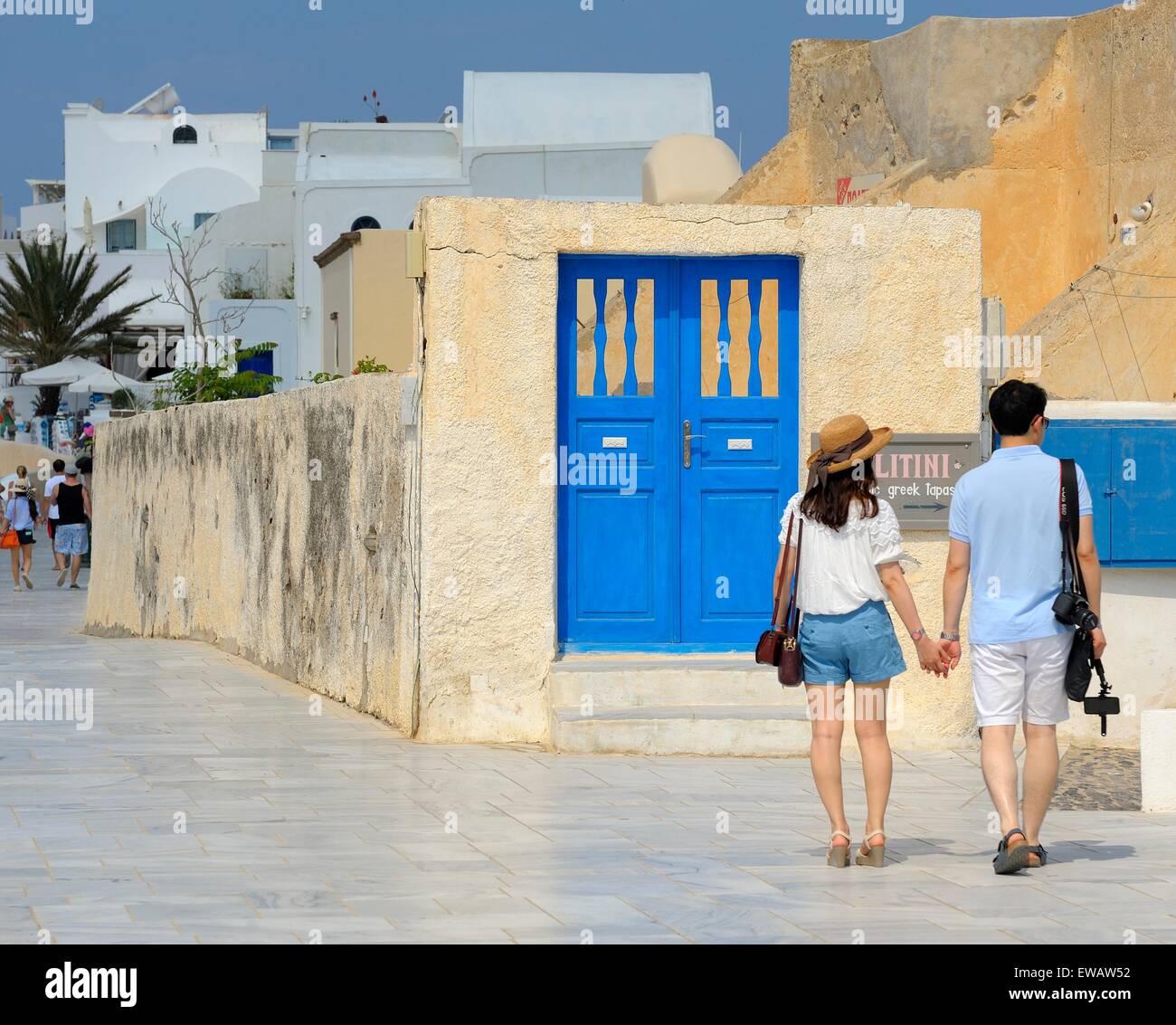 Blue painted doors and a young couple on the island of Santorini Greece. Stock Photo