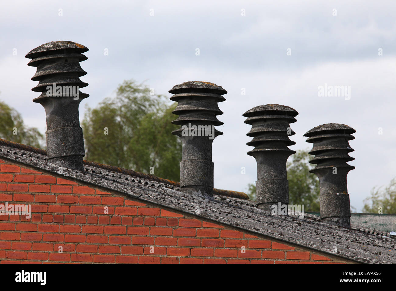 Old factory with asbestos chimney pots/flues visible above the roof ...