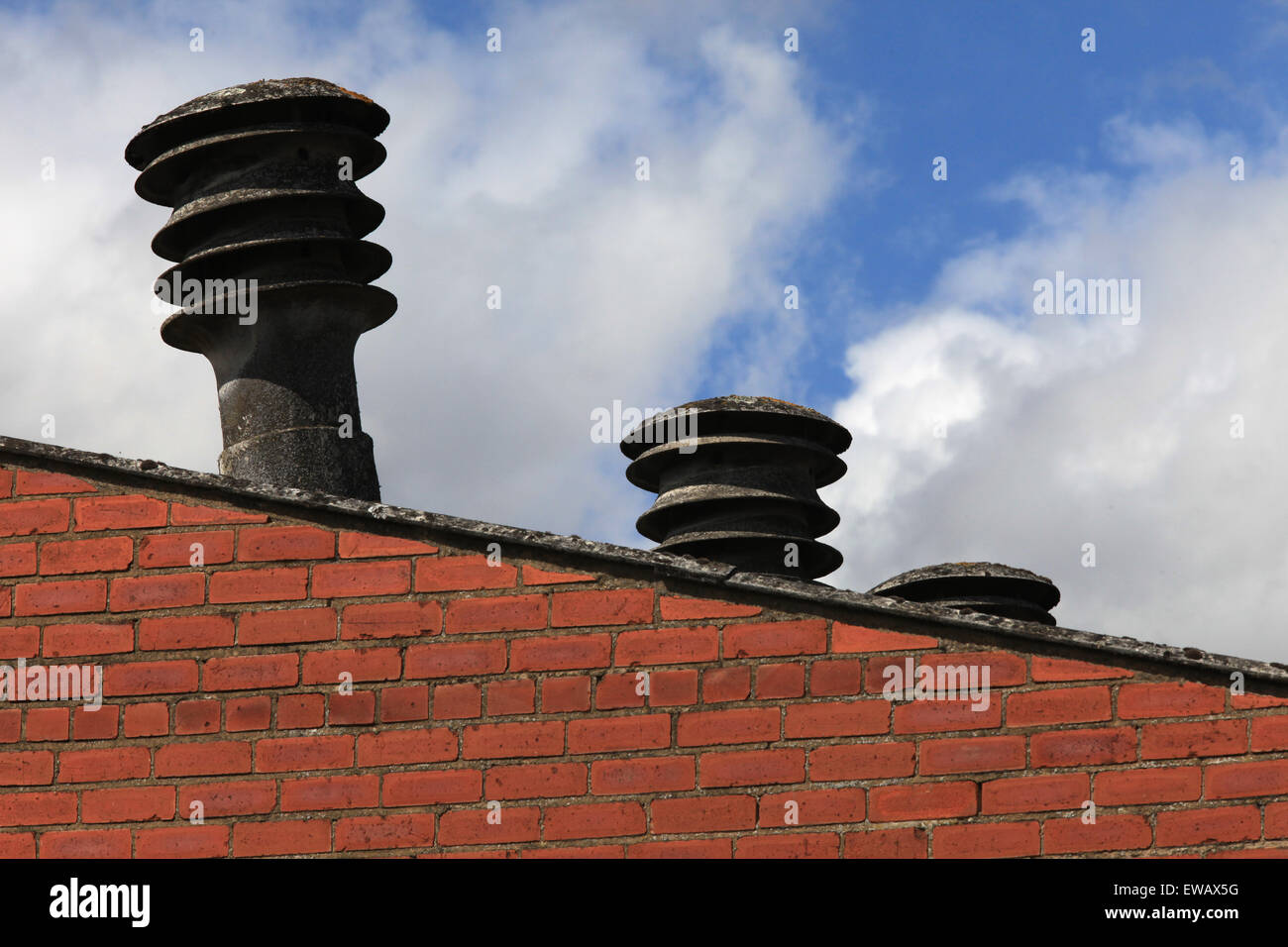 Old factory with asbestos chimney pots/flues visible above the roof ...
