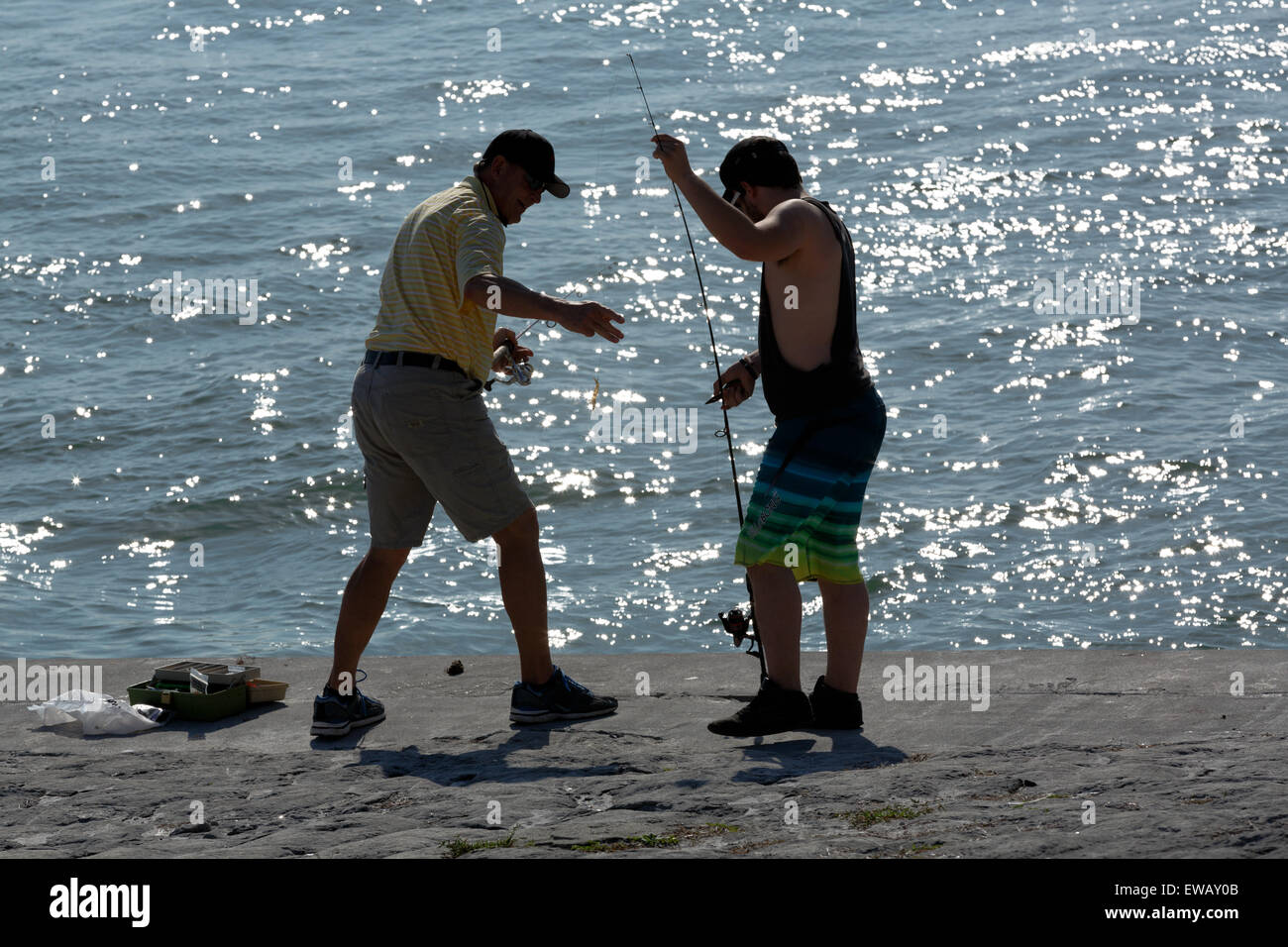 Two anglers with fishing rod as semi silhouette on the beach, Dunedin, Florida Stock Photo