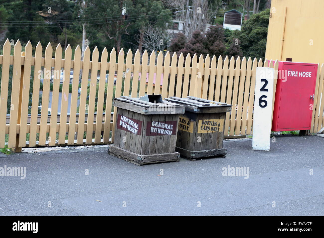 Classic wooden rubbish bins near wooden fence Stock Photo