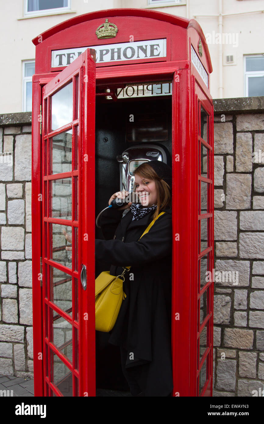 A woman using the old fashioned telephones of the British Commonwealth on the Rock of Gibraltar. Stock Photo