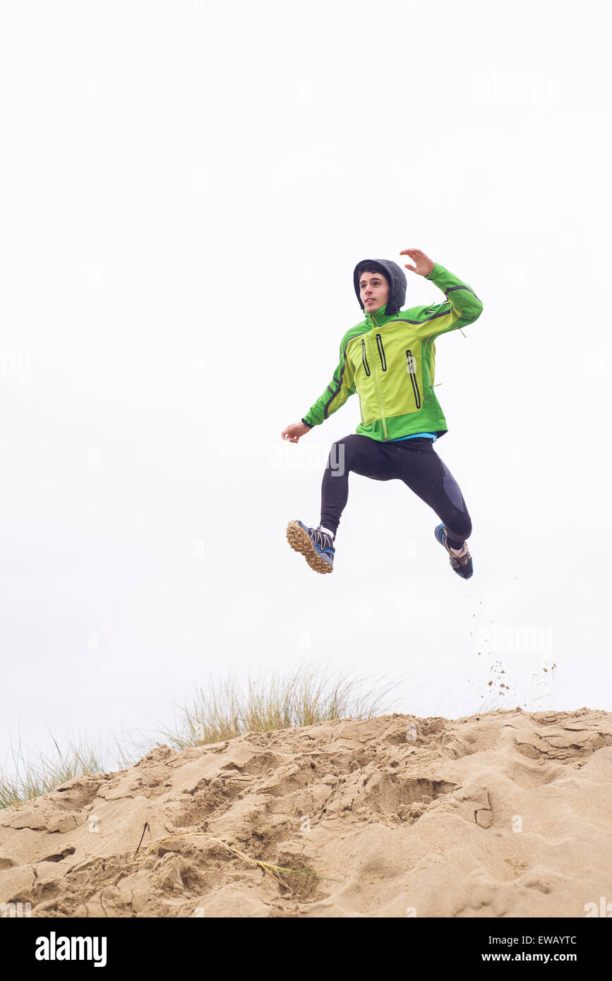 Man practicing trail running on beach in a rainy day Stock Photo