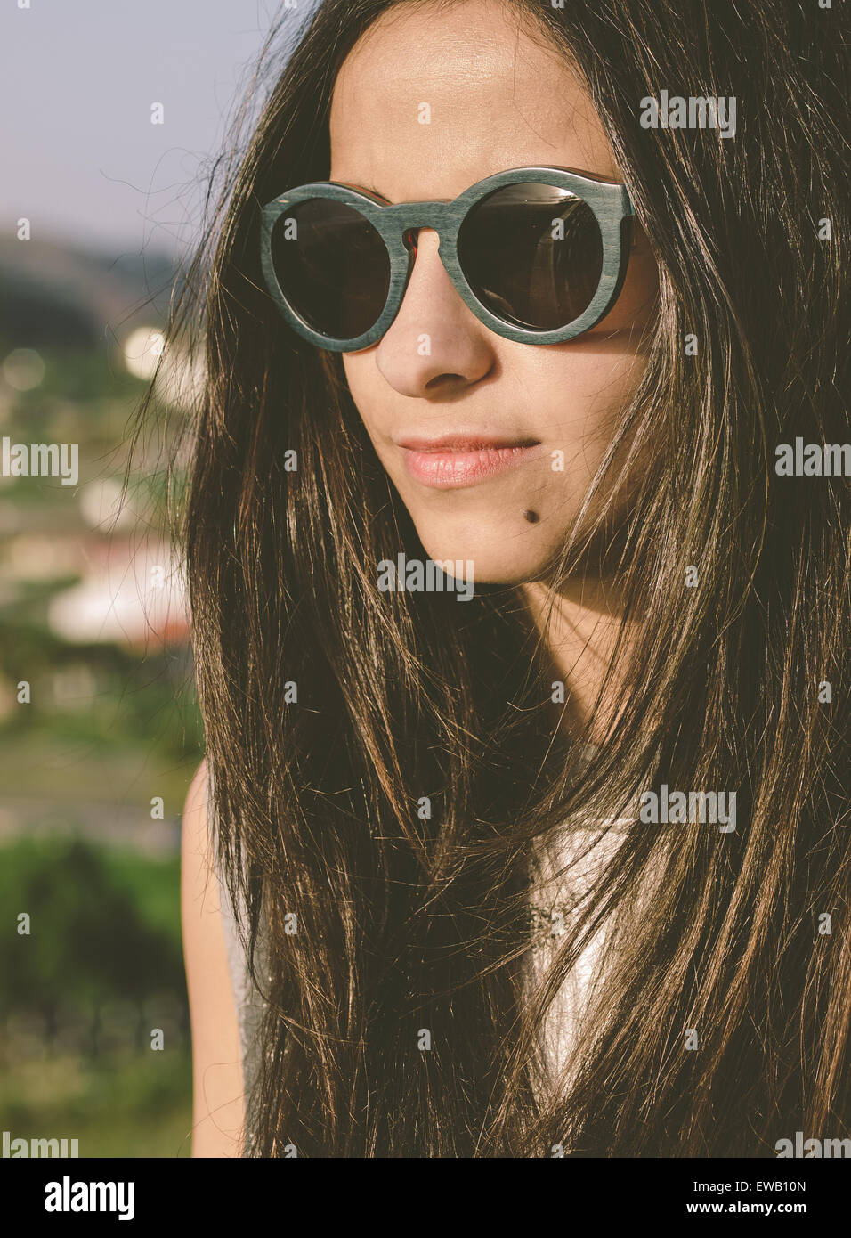 Brunette woman with sunglasses in a portrait outdoors Stock Photo