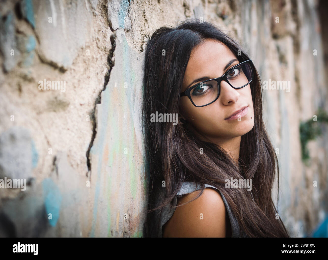 Beautiful brunette woman with sunglasses over a ruinous wall Stock Photo