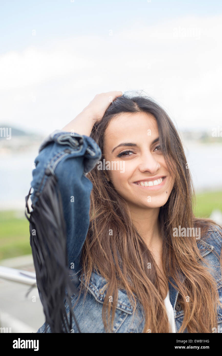 Young brunette woman smiling outdoors. Woman is happy. Stock Photo