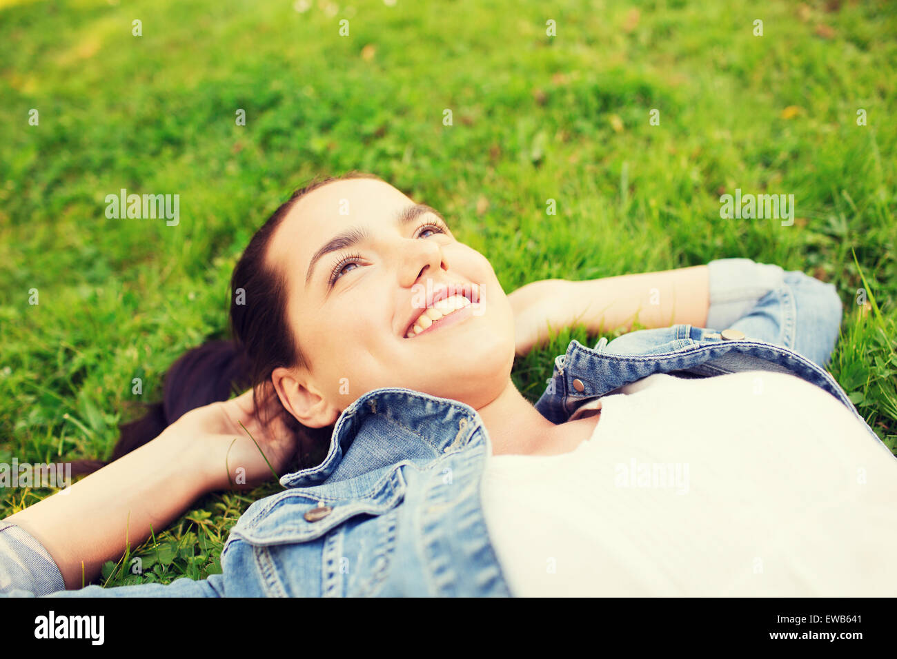 smiling young girl lying on grass Stock Photo - Alamy