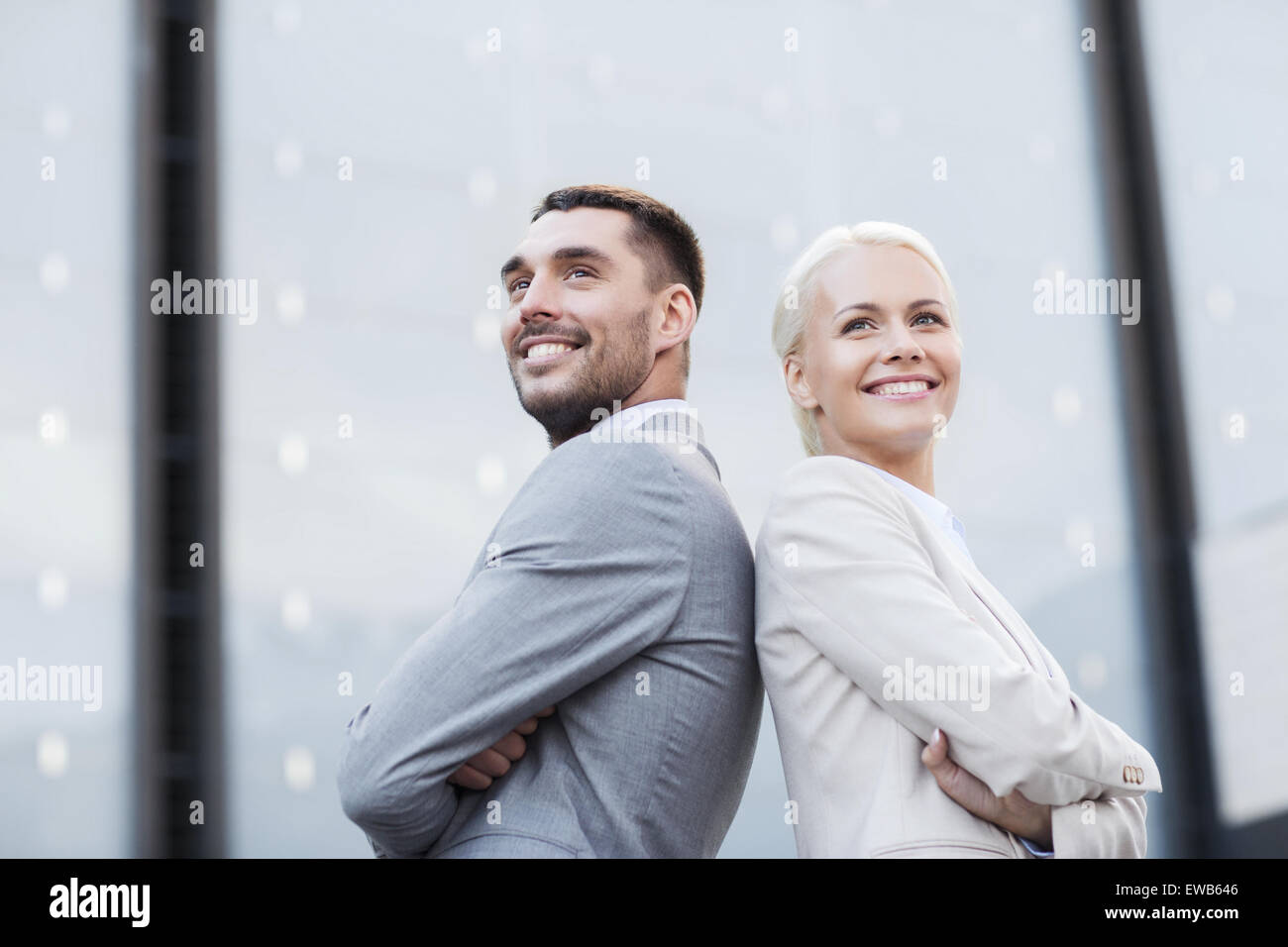 smiling businessmen standing over office building Stock Photo - Alamy
