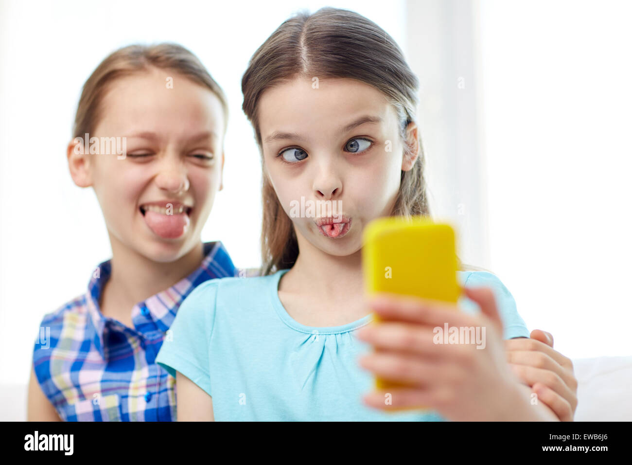 happy girls with smartphone taking selfie at home Stock Photo - Alamy