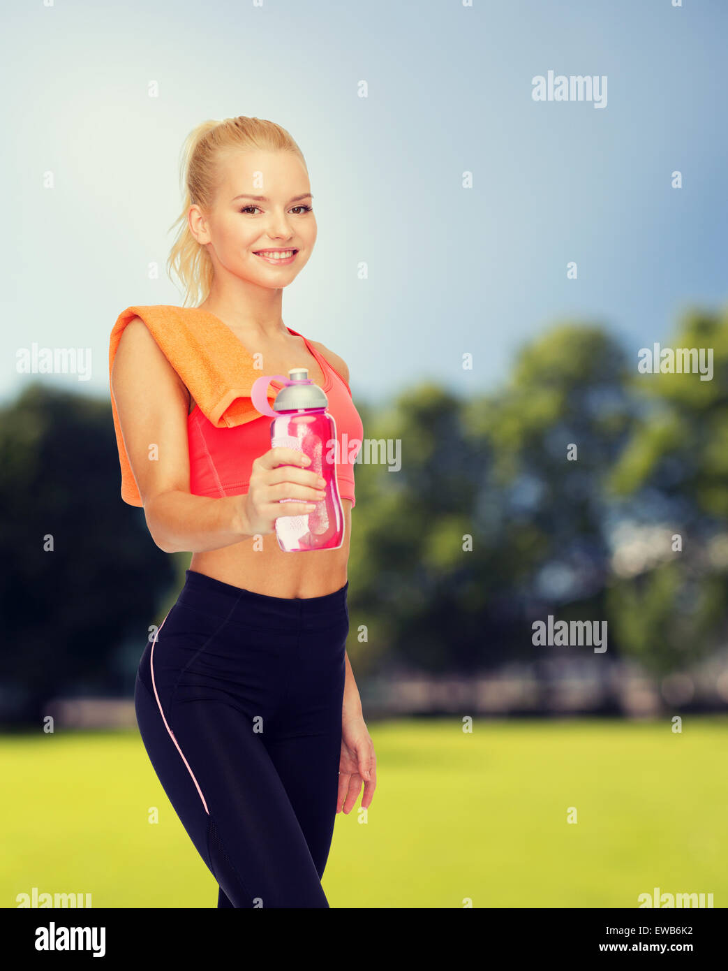 smiling sporty woman with water bottle and towel Stock Photo