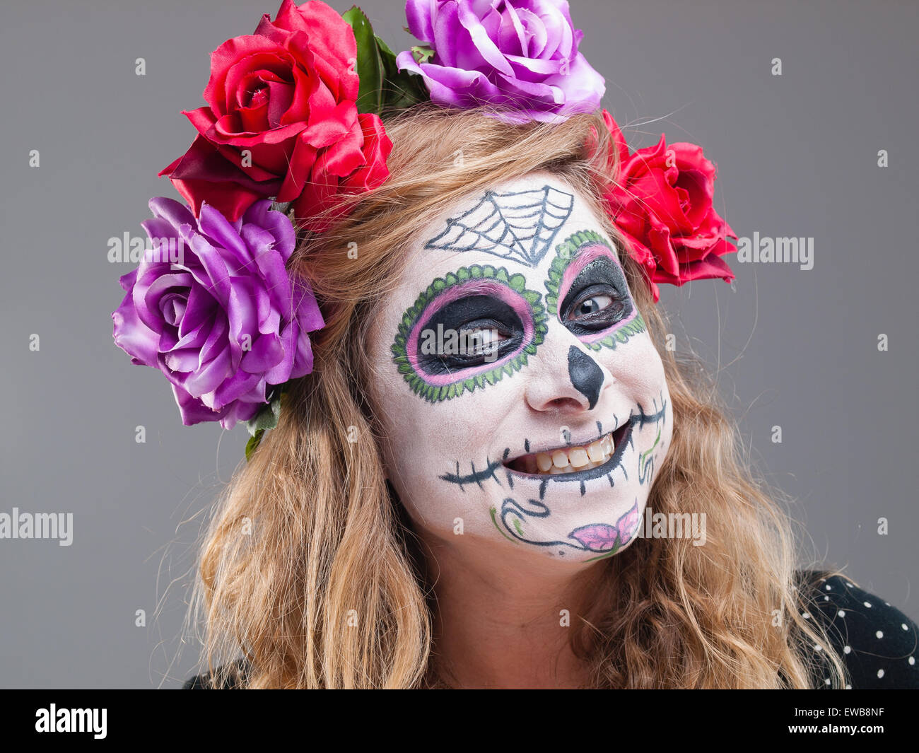 Halloween witch. Beautiful woman wearing santa muerte mask portrait in a studio shot. Stock Photo