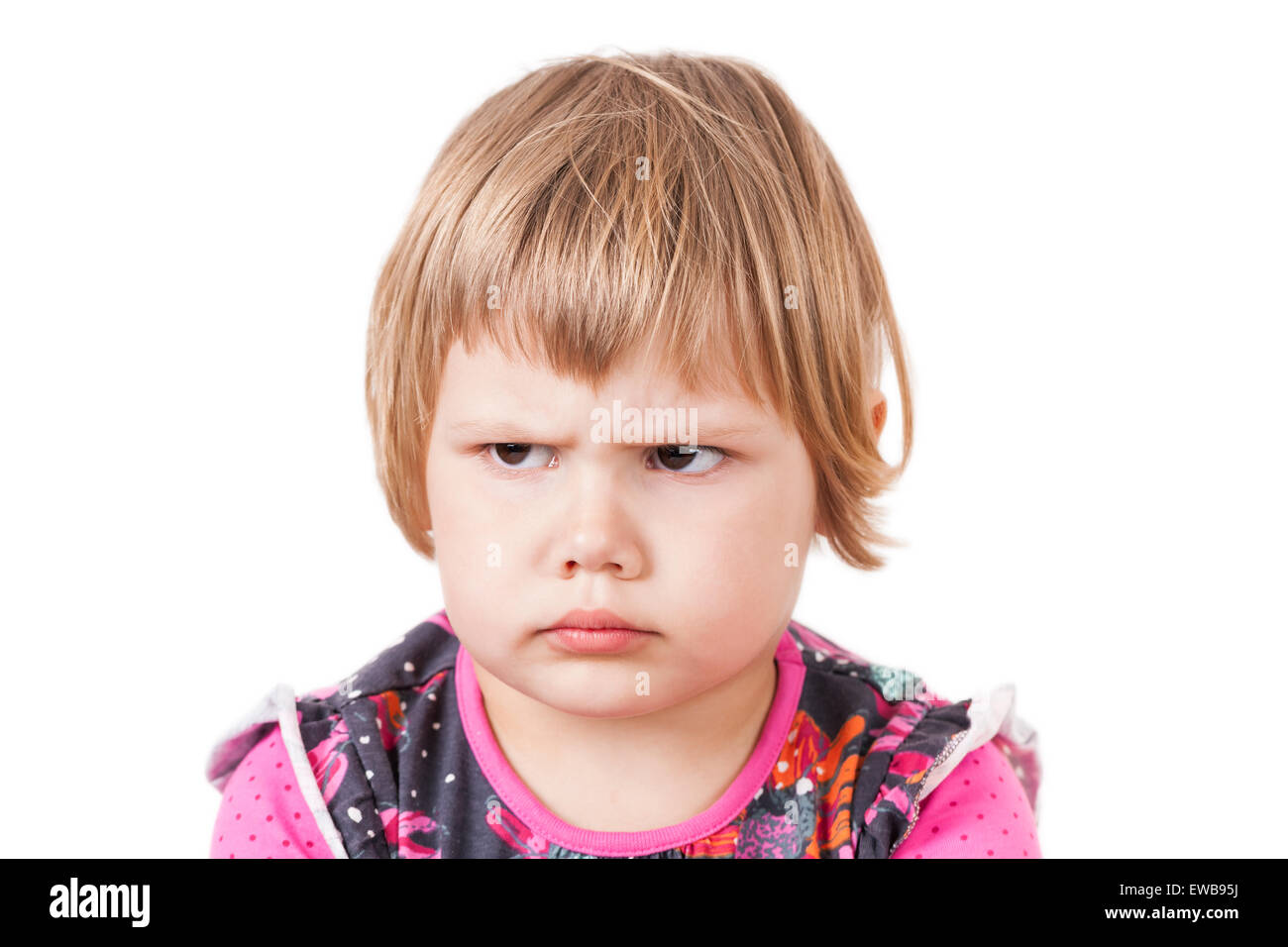 Cute small Caucasian blond baby girl angry frowns, studio portrait isolated on white background Stock Photo