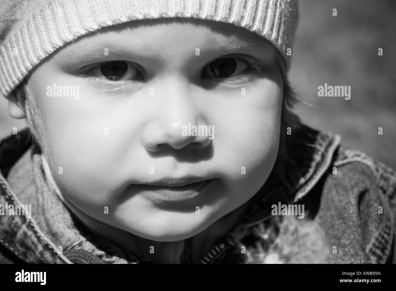 Closeup monochrome portrait of small Caucasian girl on the walk, outdoor photo Stock Photo