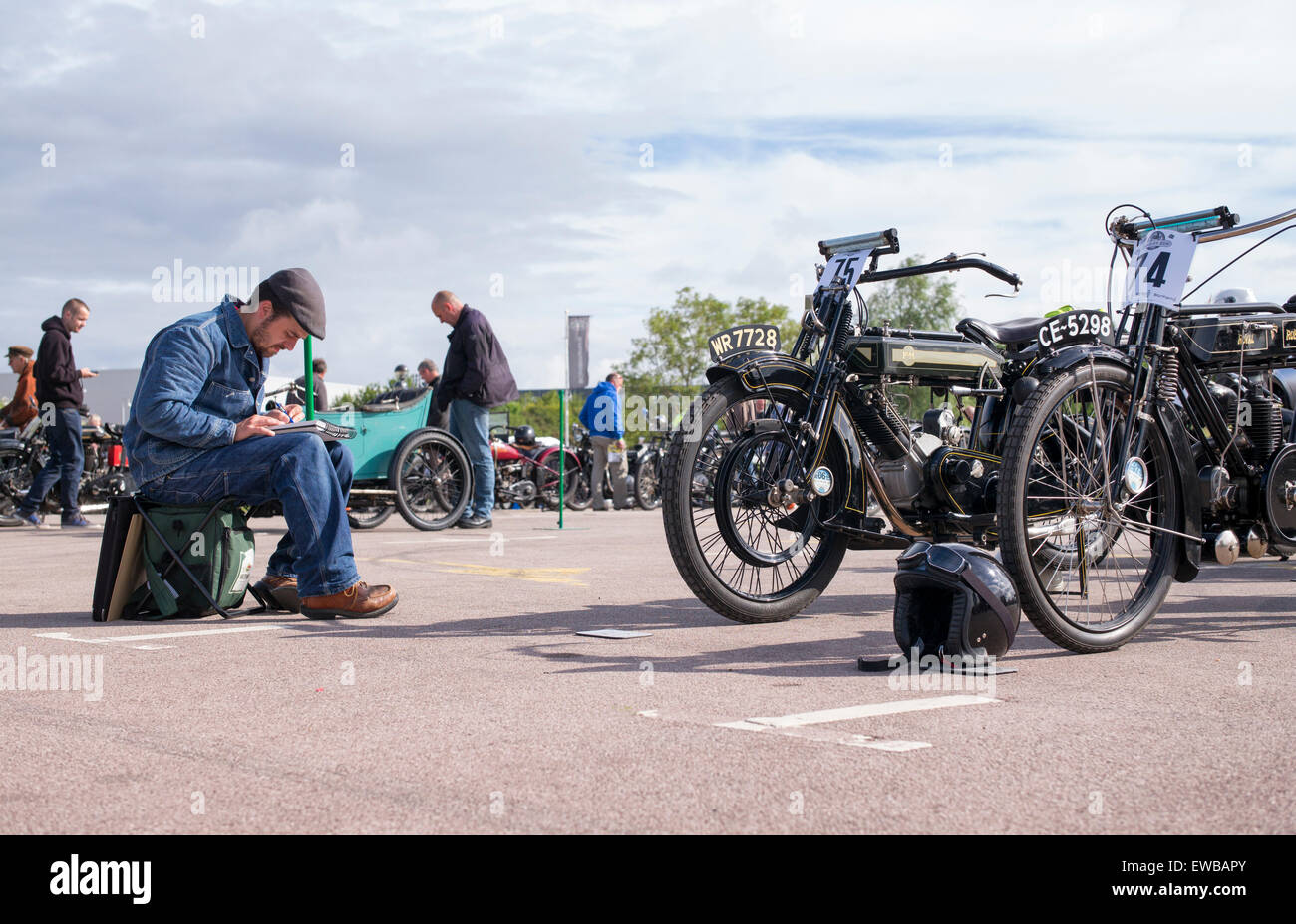 Artist sketching vintage british motorcycles at The VMCC Banbury Run. Banbury, Oxfordshire, England Stock Photo