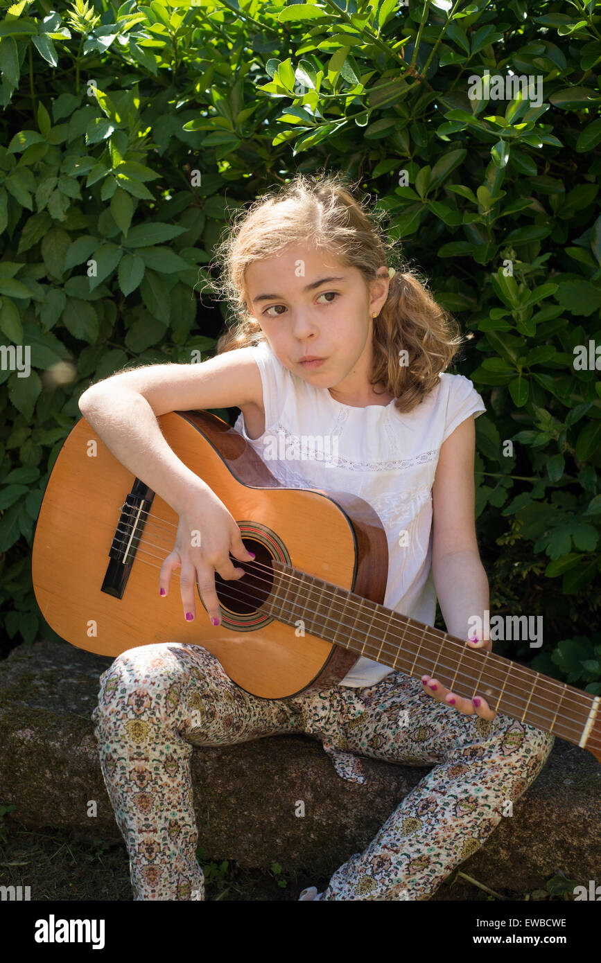 Seven years old girl playing a spanish guitar outdoors Stock Photo Alamy