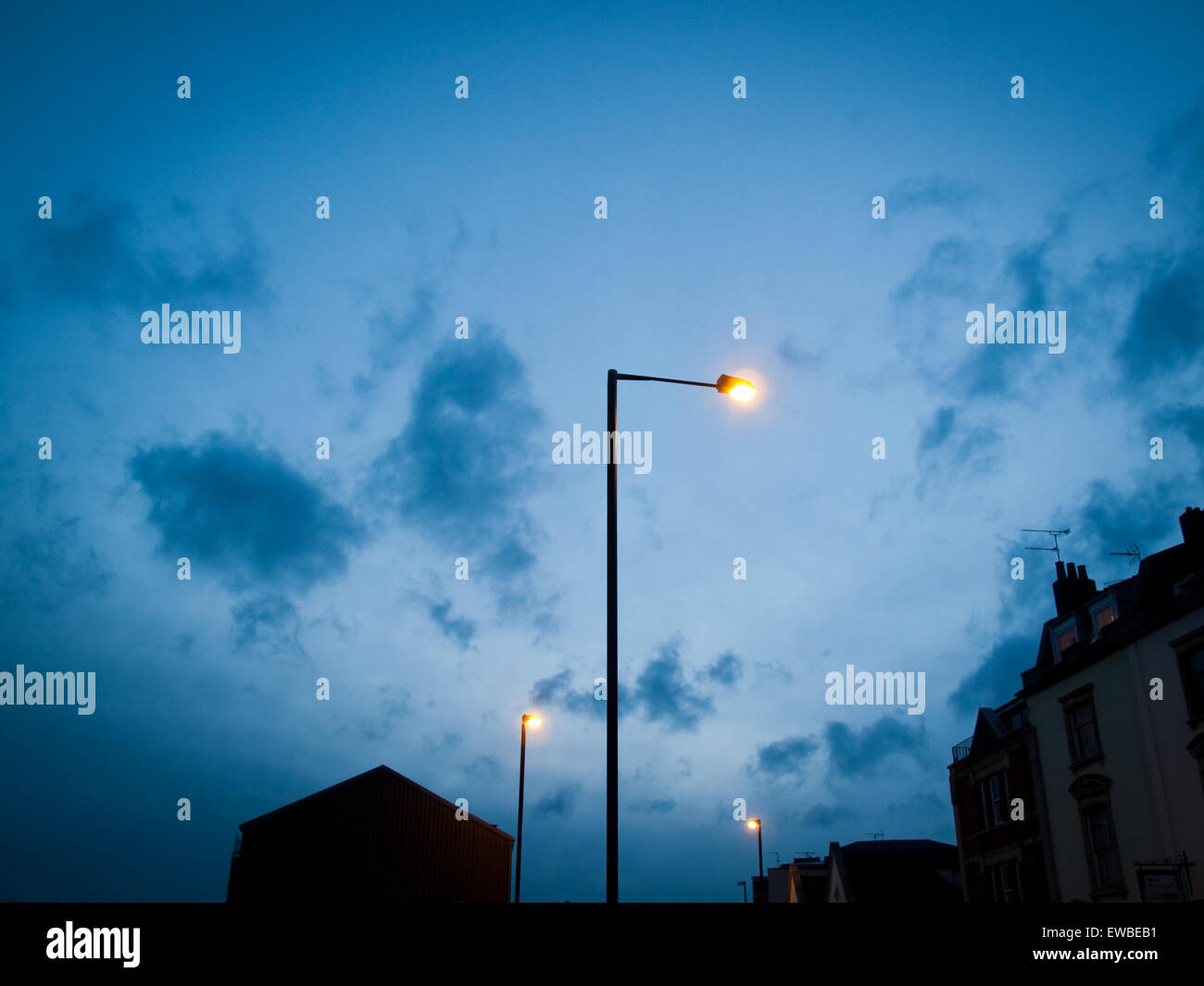 Streetlights at night in built-up suburban area of town Stock Photo