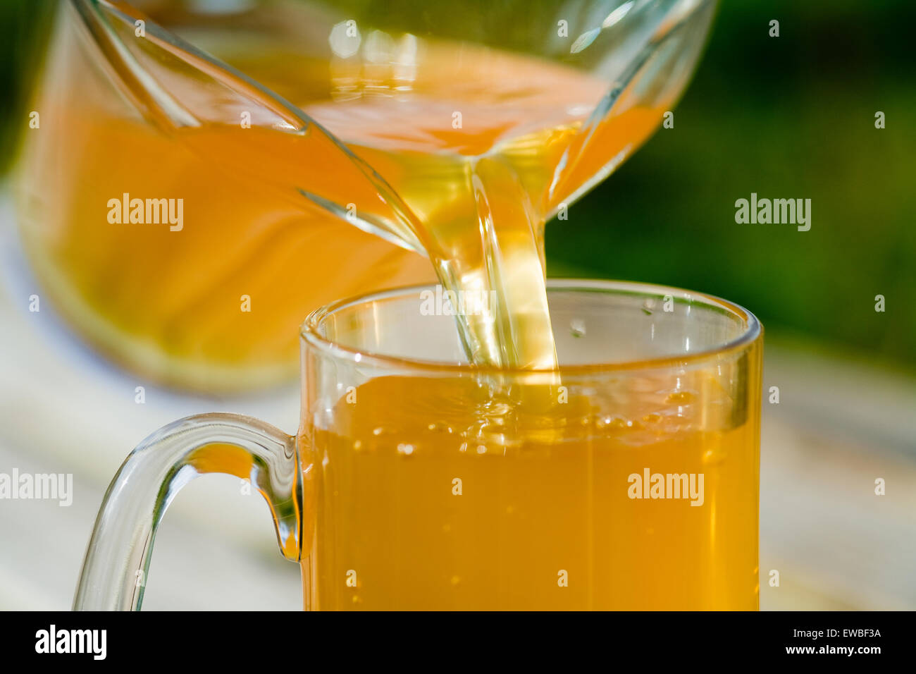 Cider being poured from glass jug Stock Photo Alamy