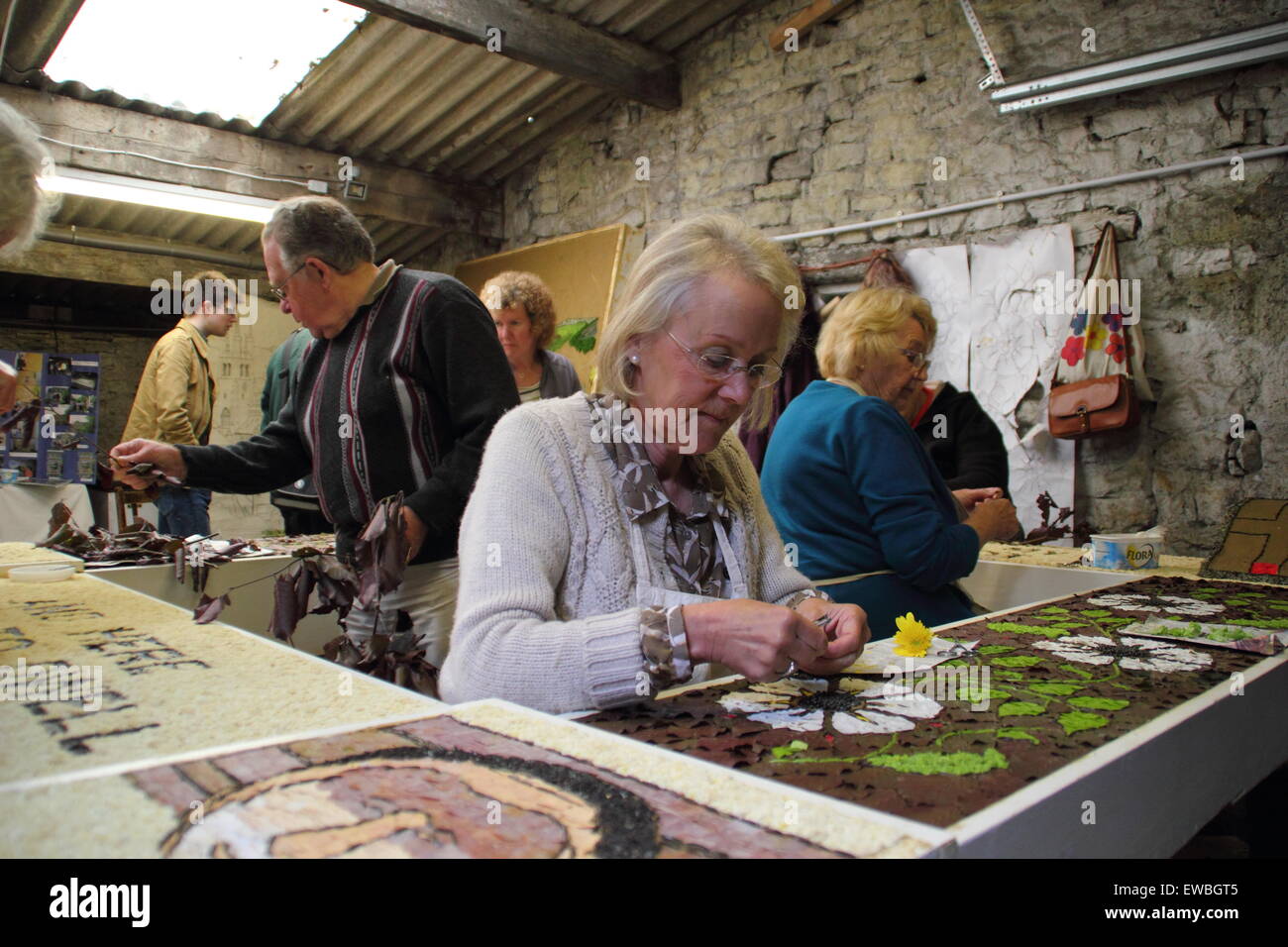 Volunteers work with natural materials to prepare Tideswell village's well dressing in the Peak District National Park, England Stock Photo