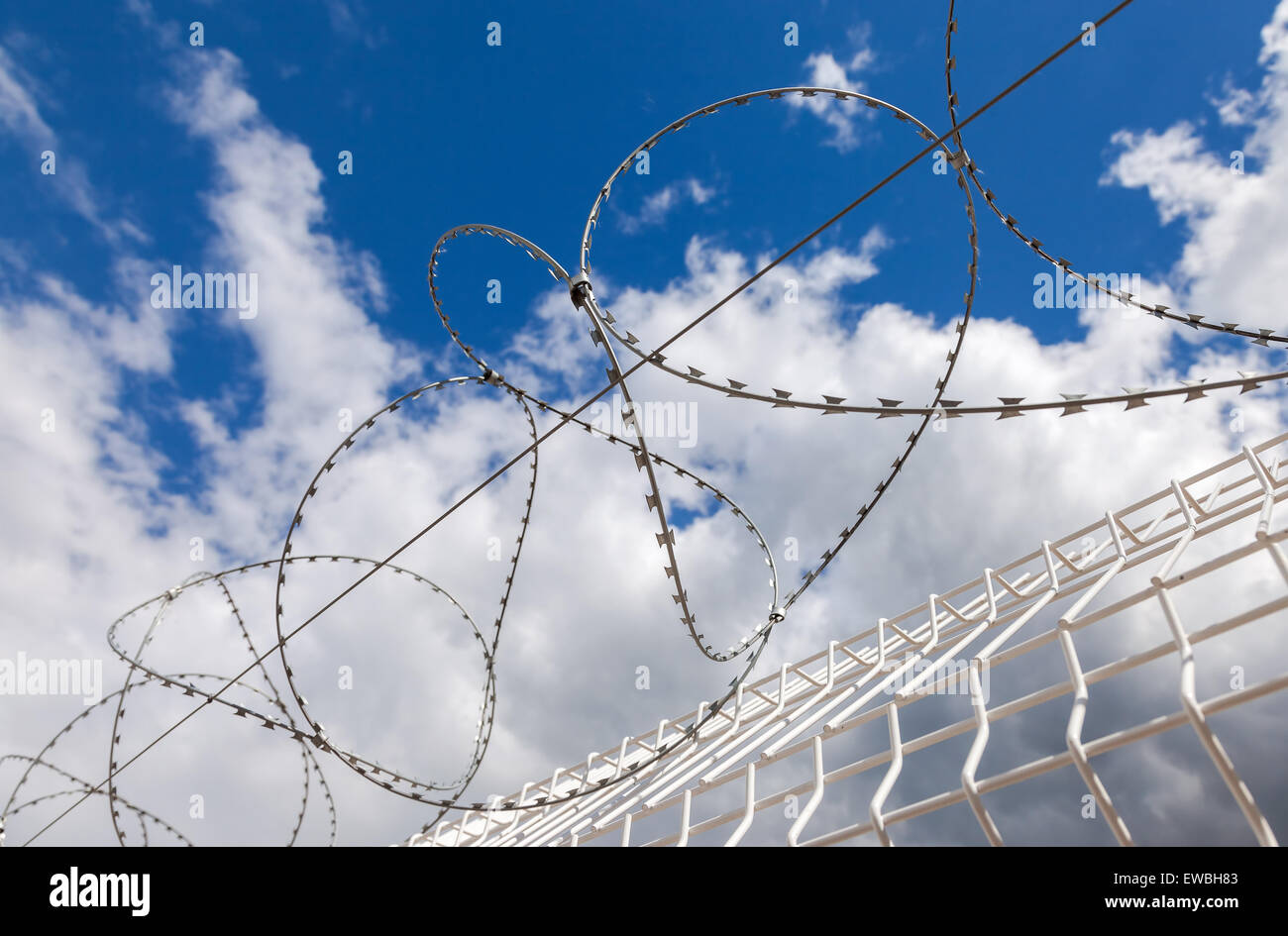 Barbed wire on blue sky background Stock Photo - Alamy