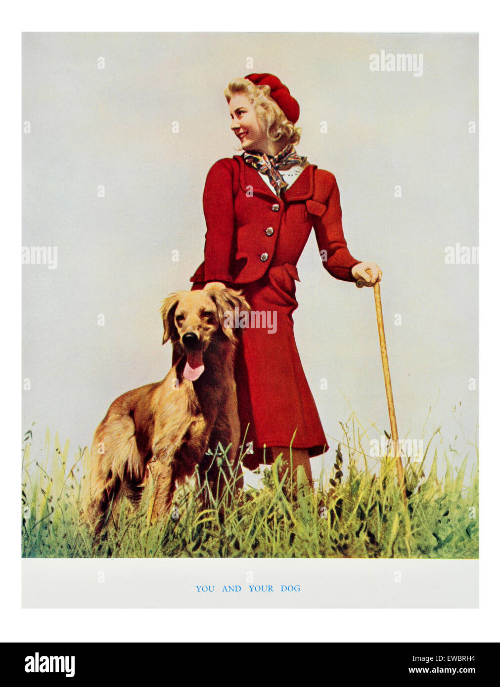 Woman in red  in the countryside walking her dog. Stock Photo