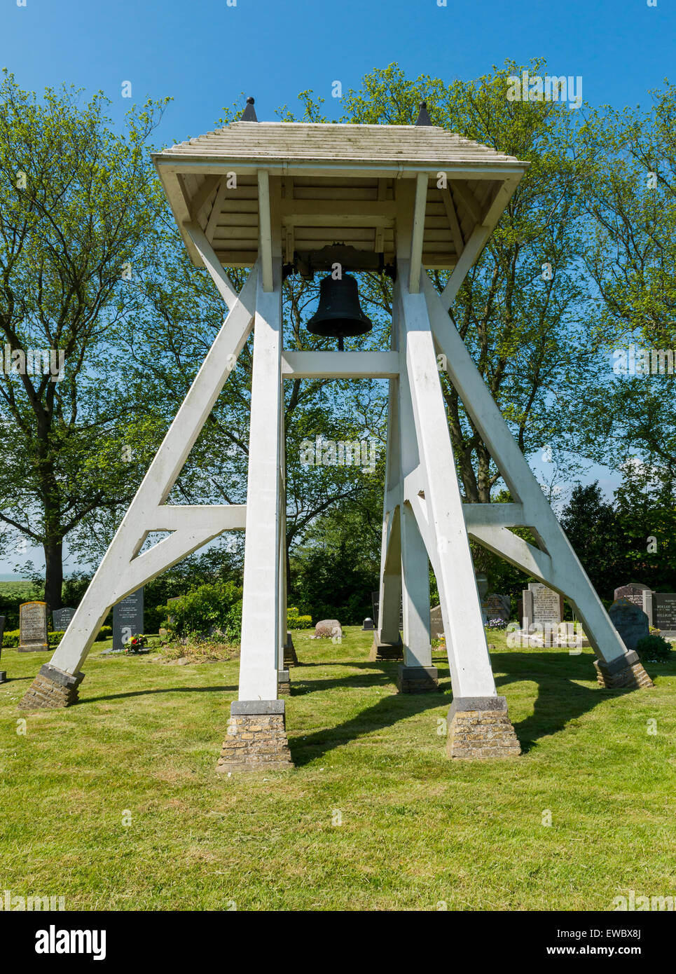 Bells on graveyard with gravestones in Mirns in province Friesland near Lemmer, The Netherlands